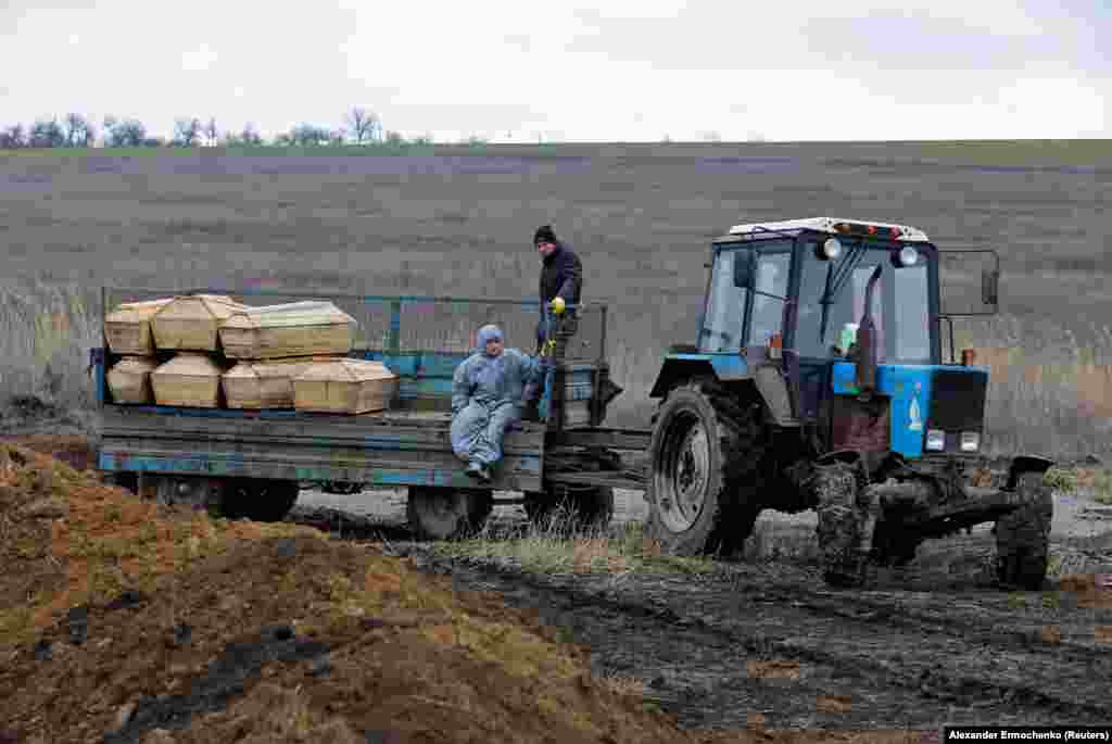 Могильщики едут с гробами, которые везут на кладбище на окраине Мариуполя. Фото от 4 февраля 2023 года. Сообщается, что тела мирных жителей находили среди обломков построек еще долго после окончания российской осады. Многие горожане скрывались от боевых действий в подвалах жилых домов