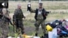 UKRAINE – A pro-Russian fighter holds up a toy found among the debris at the crash site of a Malaysia Airlines jet near the village of Hrabove, Donetsk region, July 18, 2014