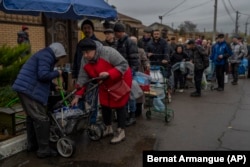 Горожане стоят в очереди, чтобы наполнить емкости с питьевой водой. Херсон, 20 ноября 2022 года