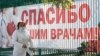 Медицинский работник на фоне баннера «Спасибо нашим врачам». Судак, Крым, 21 октября 2021 года. Иллюстрационное фото