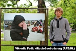 Макс Левин рядом со своей фотографией на выставке "Донбасс: война и мир". Прага, 20 мая 2015 года