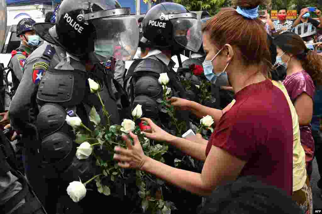 Протестующие дарят белые цветы полиции в Янгоне 6 февраля. Фотография очень напоминает сцены в Минске в начале осени 2020 года&nbsp;