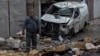 CORRECTION / A man stands among debris next to a destroyed car following a drone attack in Odesa on November 10, 2024, amid the Russian invasion in Ukraine.