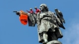 SPAIN -- Activists from the Spanish Proactiva Open Arms charity place a life jacket on the Christopher Columbus statue after the Open Arms rescue boat arrived at a port in Barcelona, Spain, carrying migrants rescued off Libya, July 4, 2018