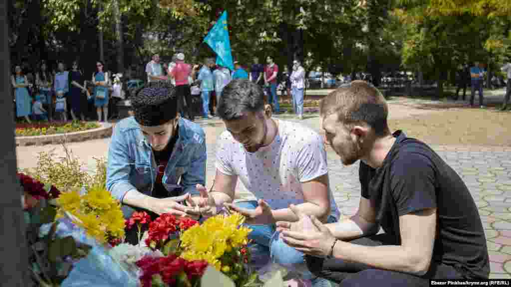 Еще до начала многие крымские татары начали подходить к памятному знаку, возлагать цветы и читать молитву